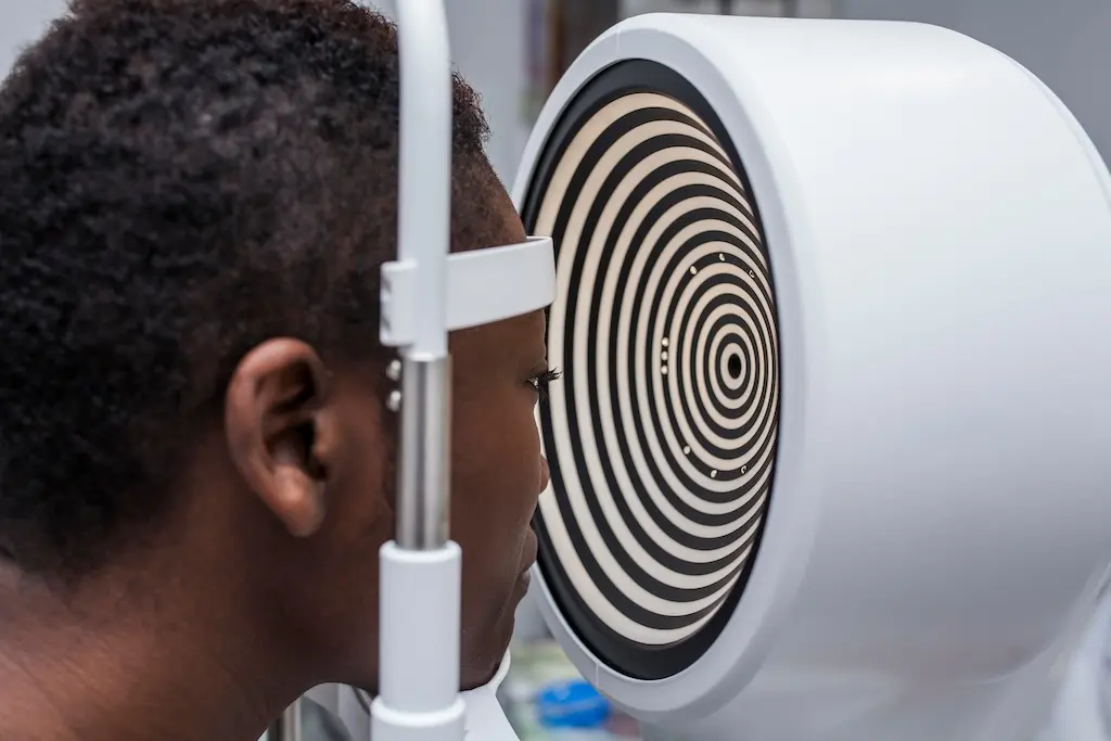 Image of face pressed against support in front of eye machine.
